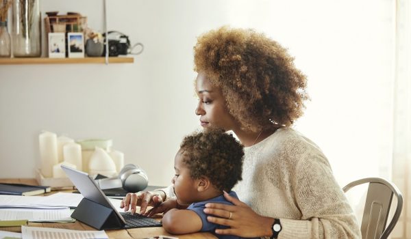 Boy looking at mother using digital tablet. Woman sitting with son at table in kitchen. She is working from home. (Boy looking at mother using digital tablet. Woman sitting with son at table in kitchen. She is working from home., ASCII, 114 components